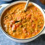 Colorado green chile in a Dutch oven with a ladle up close.