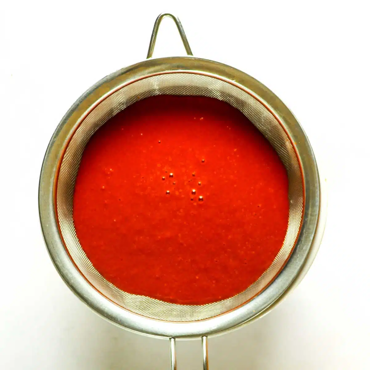 Sauce that has been poured into a strainer.