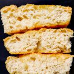 Three pieces of vegan focaccia stacked on top of each other.