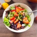 Balsamic feta strawberry salad in a large salad bowl with fork.