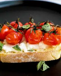 Air fryer cherry tomatoes on a the vine roasted on top of toast.