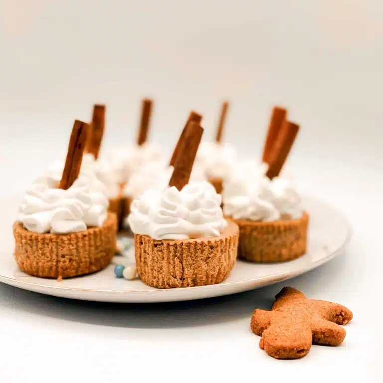 Seven decorated mini gingerbread cheesecakes.