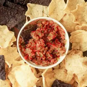 Spicy habanero salsa in a ramekin surrounded by chips.
