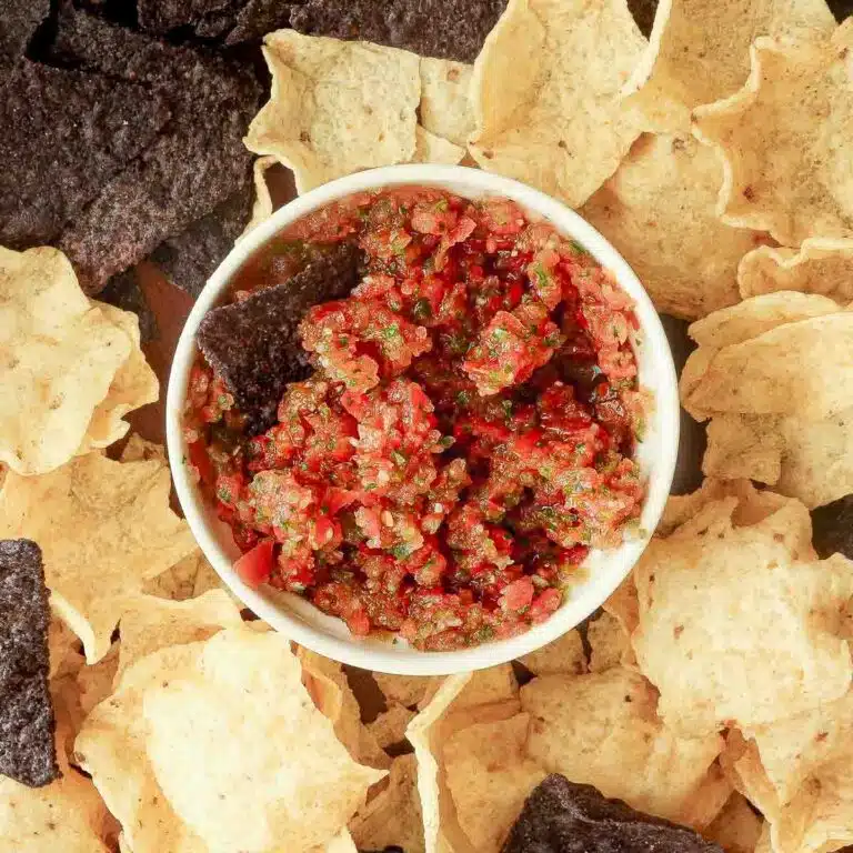 Spicy habanero salsa in a ramekin surrounded by chips.