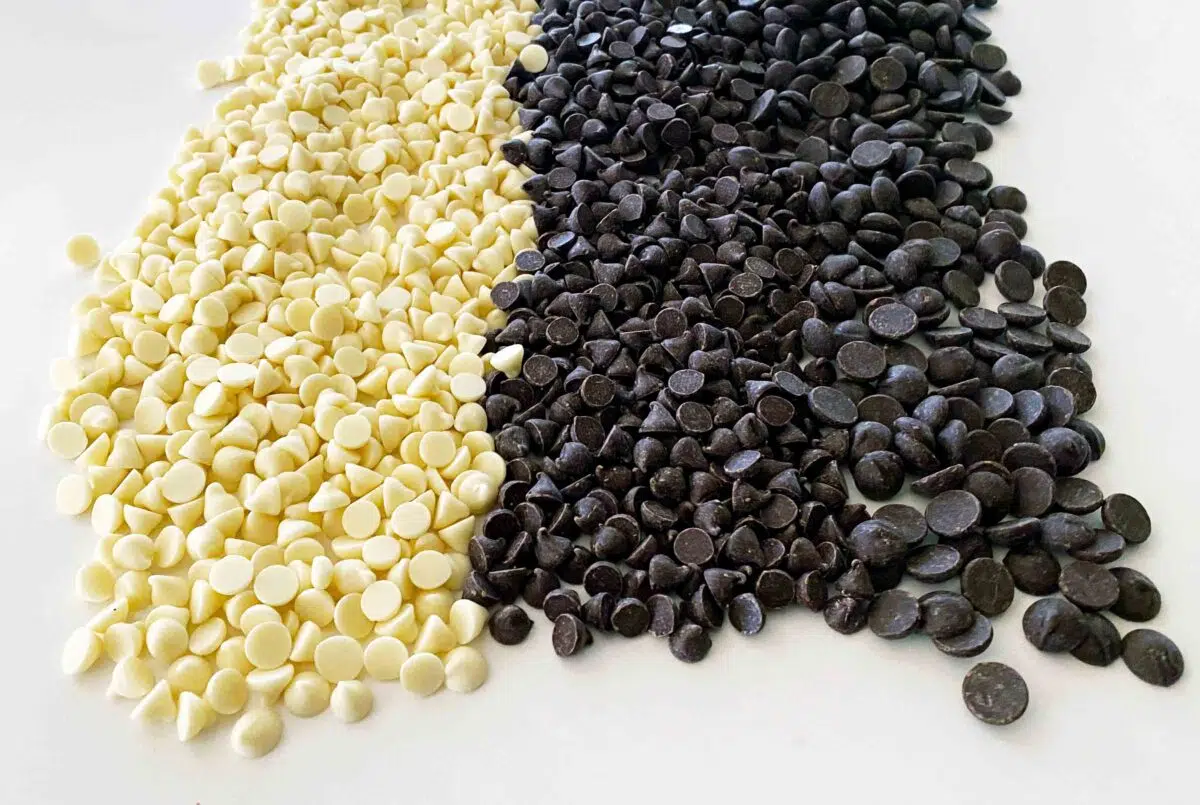 White, milk and dark chocolate chips laid out in three lines. 