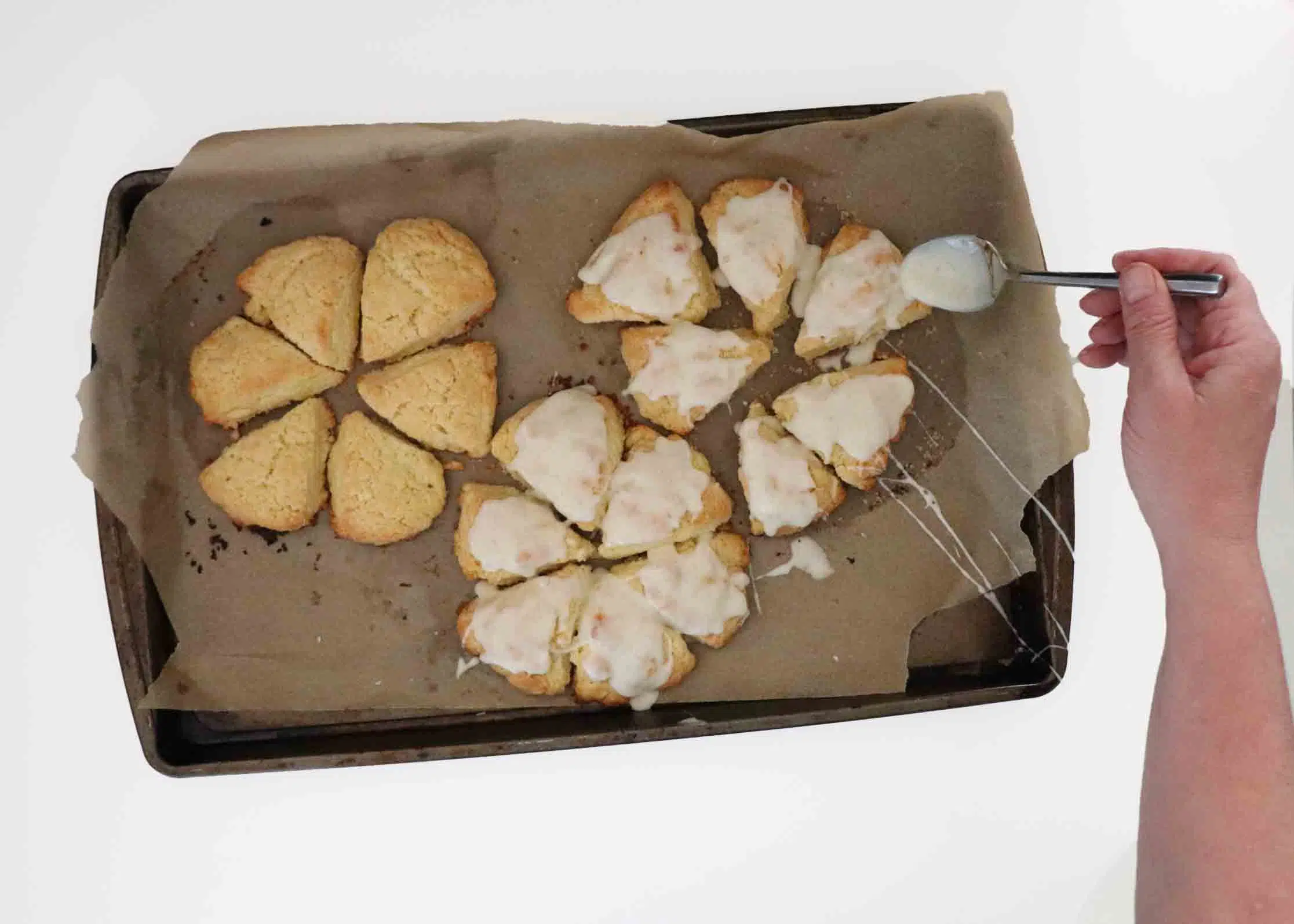 Spooning glaze over baked scones.