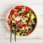 Large bowl filled with tossed Greek cucumber salad.