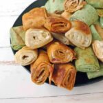 Pilled grilled cream cheese pinwheels stacked on a plate.