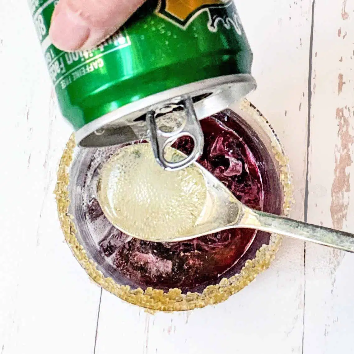 Top down view of ginger ale being poured onto a spoon. 