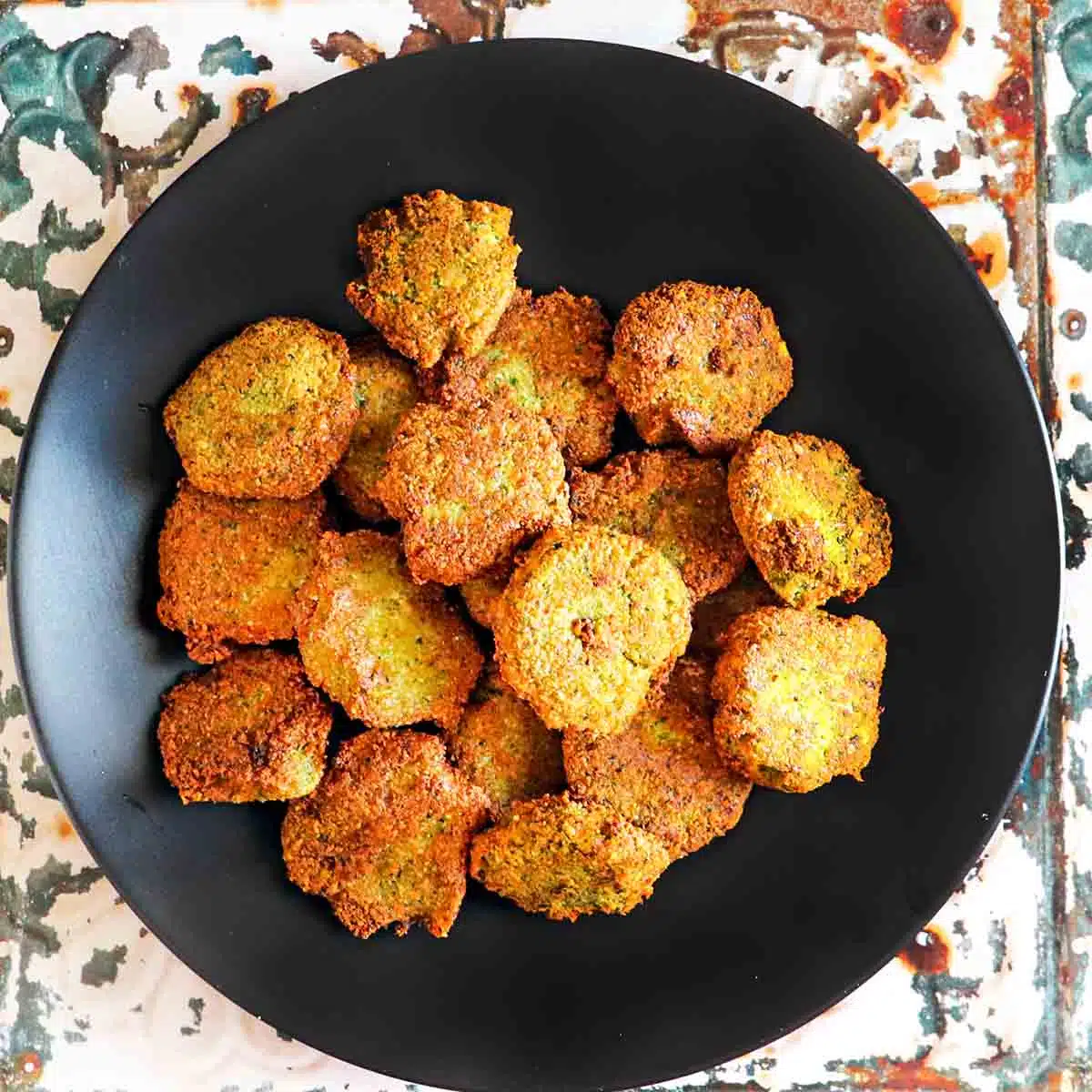 Several cooked falafel patties on a plate.