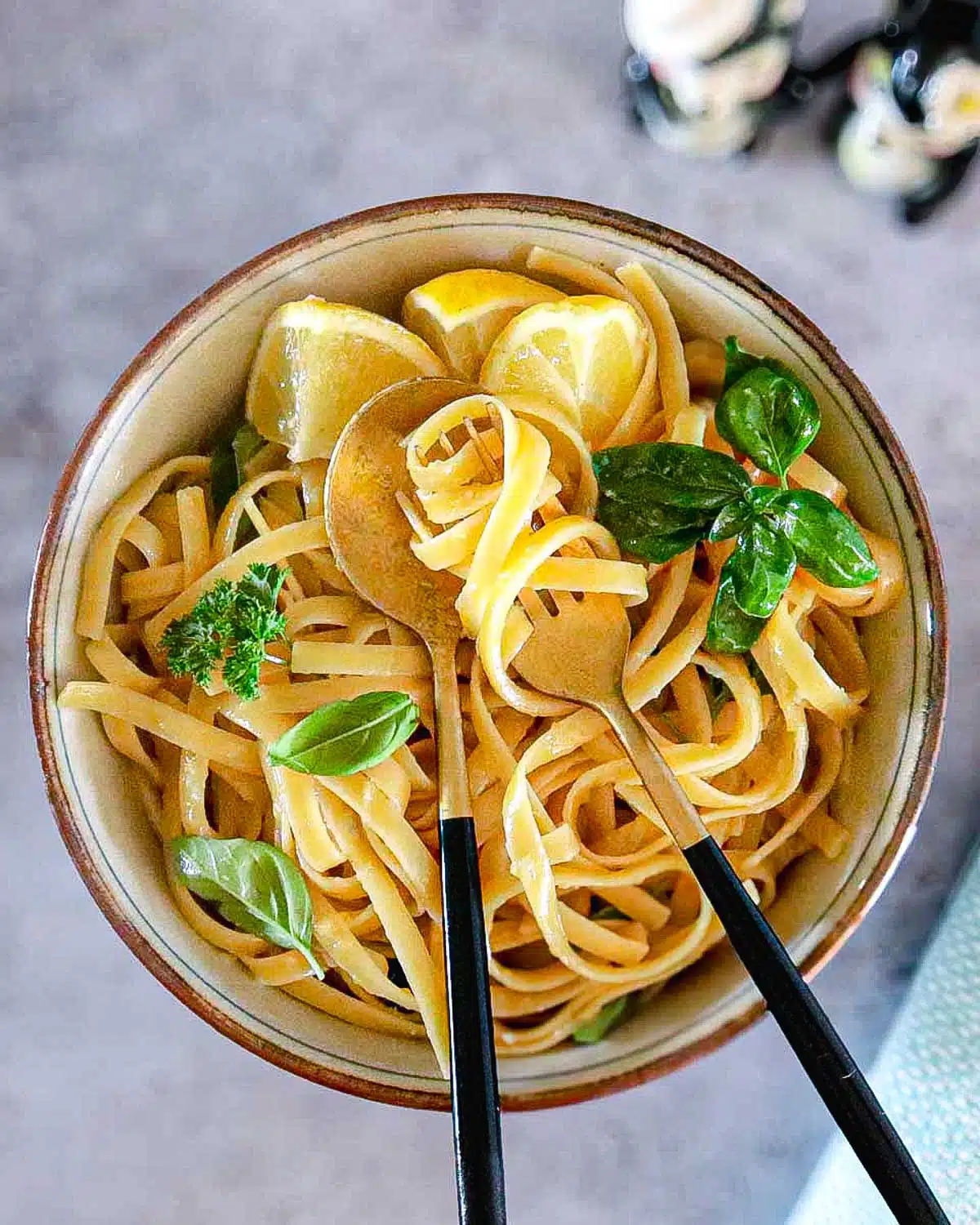 A bowl filled with lemon pasta, with the noodles wrapped around the fork. 