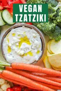 A bowl of vegan tzatziki surrounded by veggies.