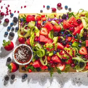 Cutting board filled with rainbow salad ingredients.