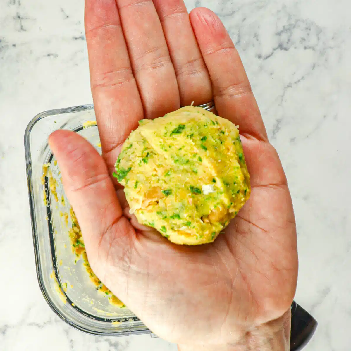 Falafel patty being held in a palm.