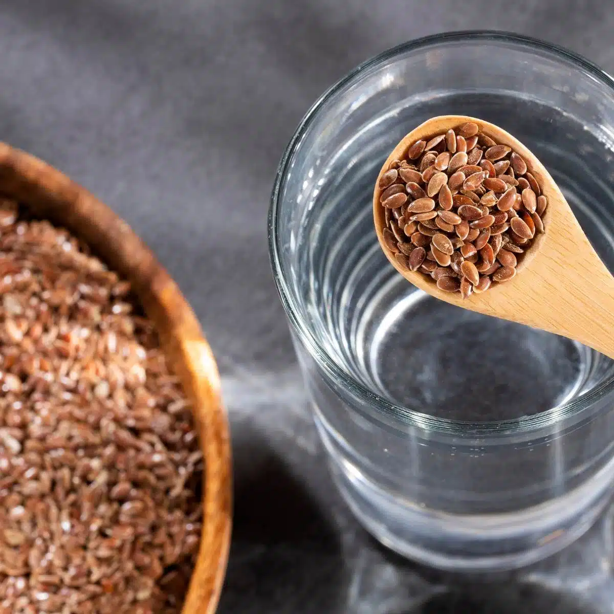 Flax see in a spoon over a glass of water.