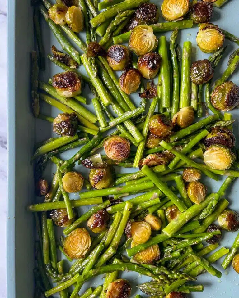 Brussel sprouts and asparagus on a baking sheet.