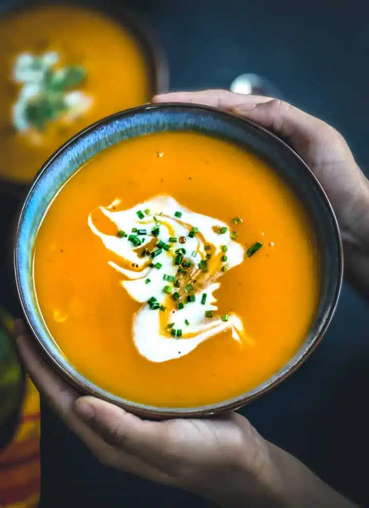 Hands cupping a bowl of soup.