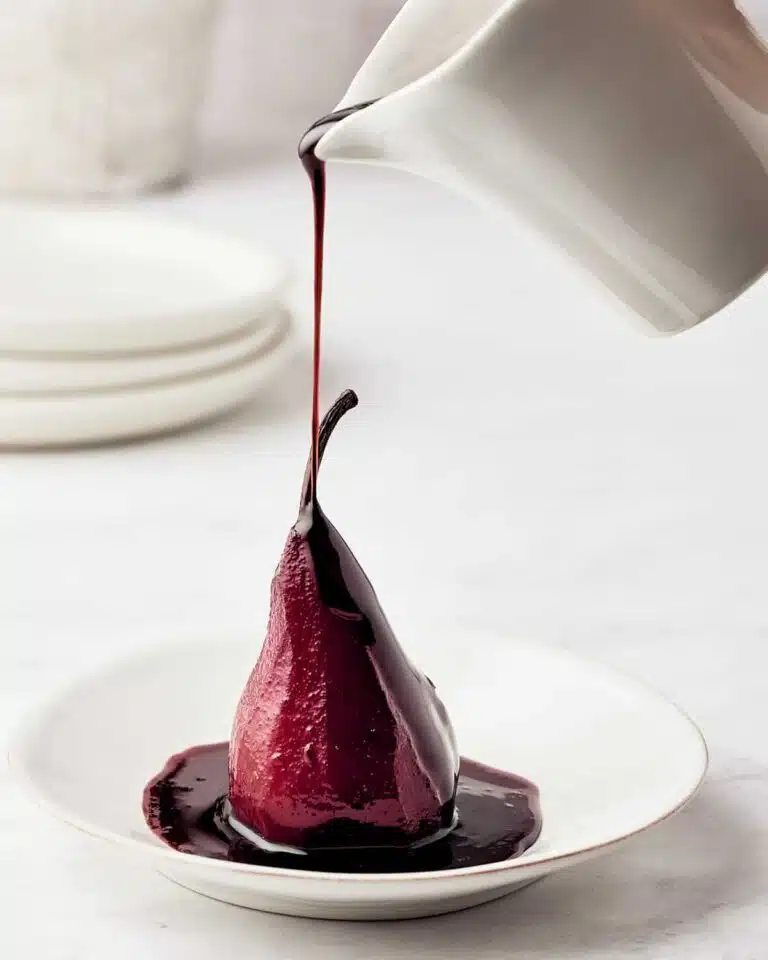 Wine being poured onto a pear.