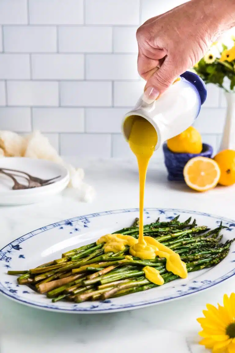Pouring sauce over asparagus. 