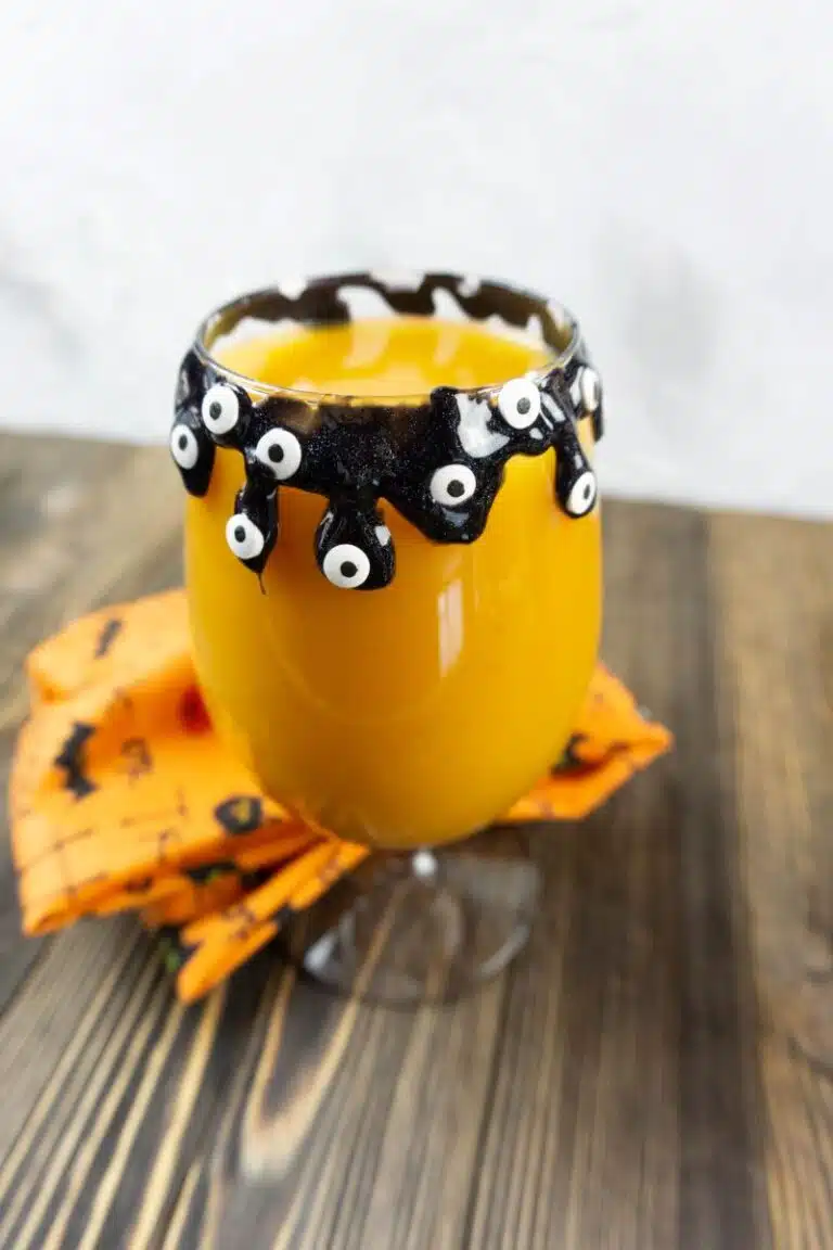 Orange cocktail with spooky eyes dripping off the sides.