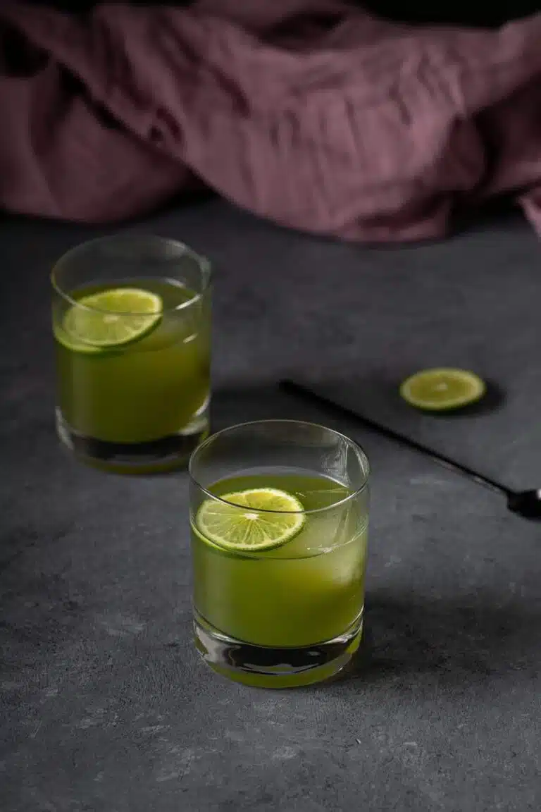 Green drink with a slice of lime floating on top.