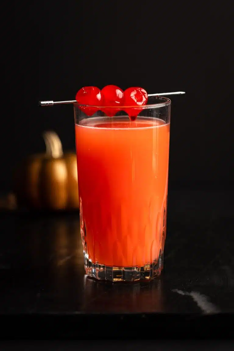 Cocktail with garnished with three cherries.