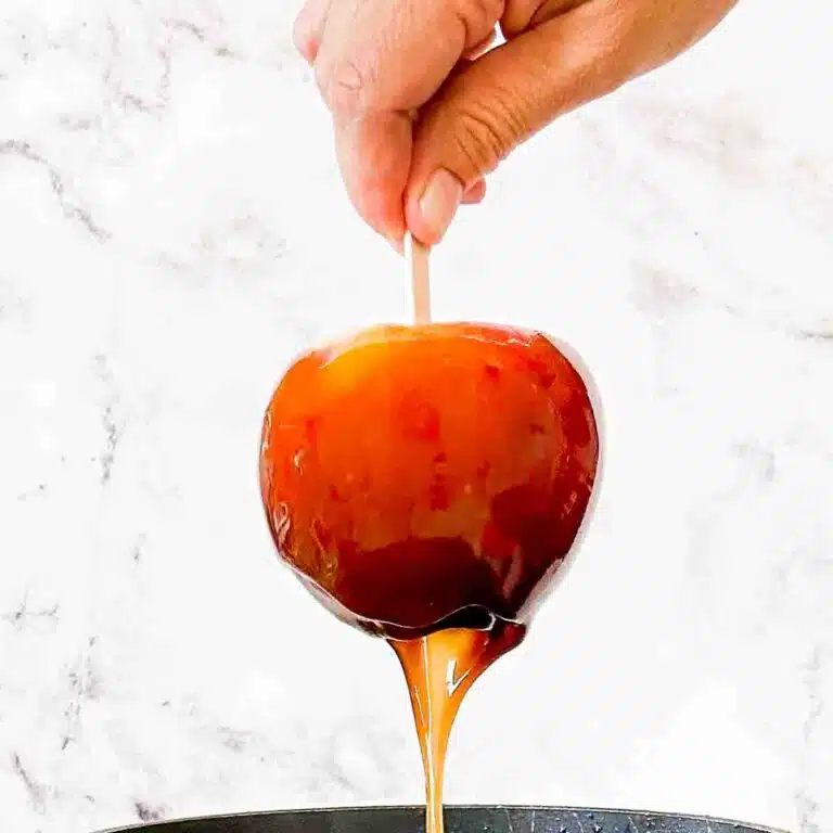 Caramel dripping off an apple up close.