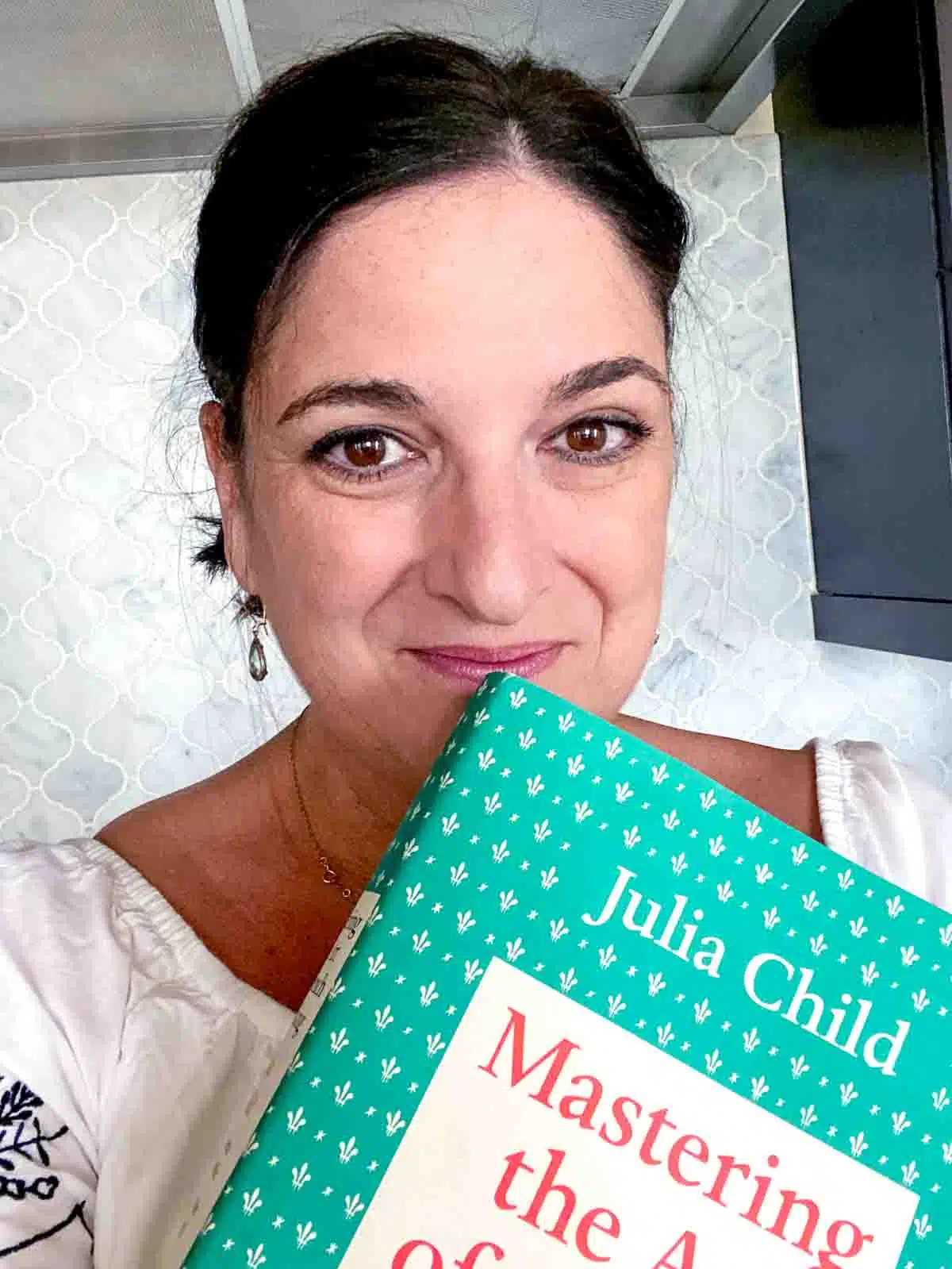 Ruth holding a copy of Mastering the Art of French Cooking