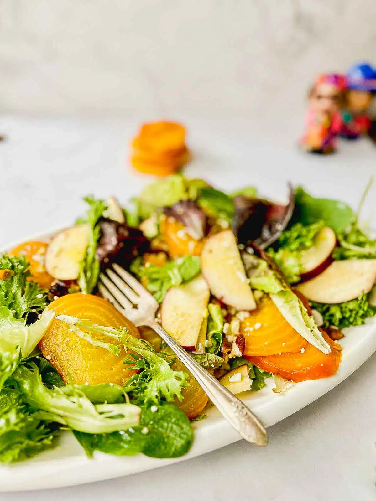 Salad that has had a few bites and a fork resting. 
