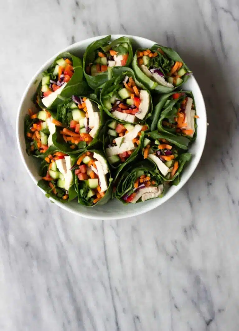 A platter filled with vegetable wraps in collard greens.