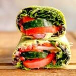 Mediterranean wrap sandwich cut in half and stacked on top of each other.