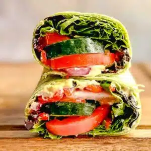 Mediterranean wrap sandwich cut in half and stacked on top of each other.