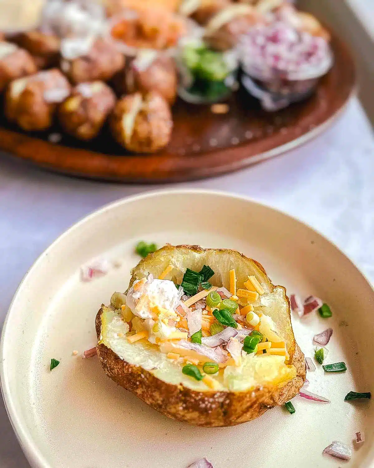 Fully loaded baked potato on a plate.