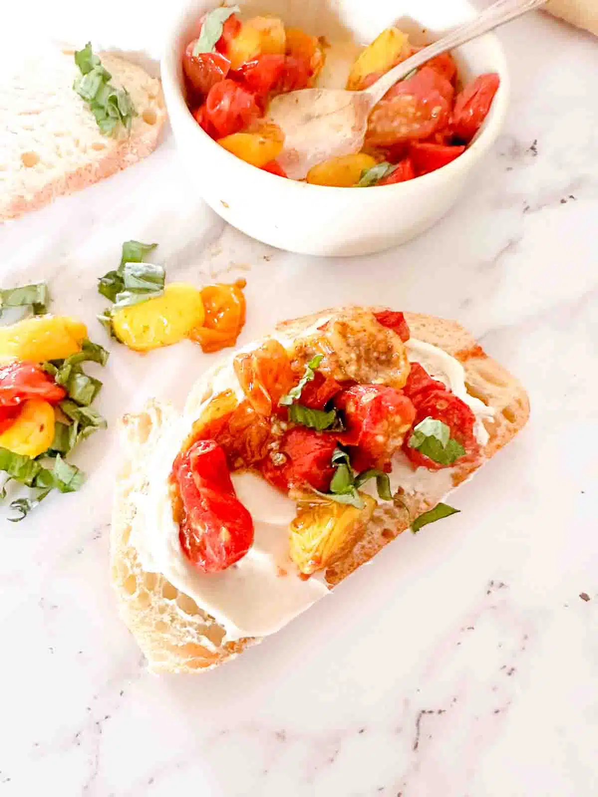 Air fryer tomatoes on top of toast with cream cheese and basil. 