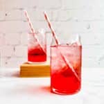 Two summer berry drinks next to each other with straws.