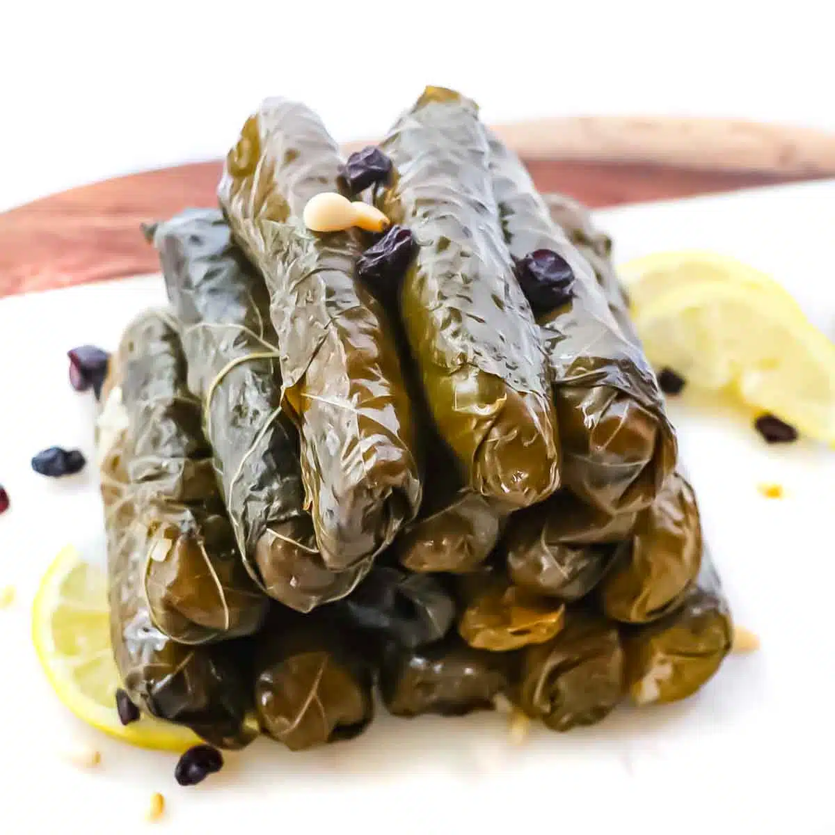 Stuffed Turkish grape leaves stacked on a platter.