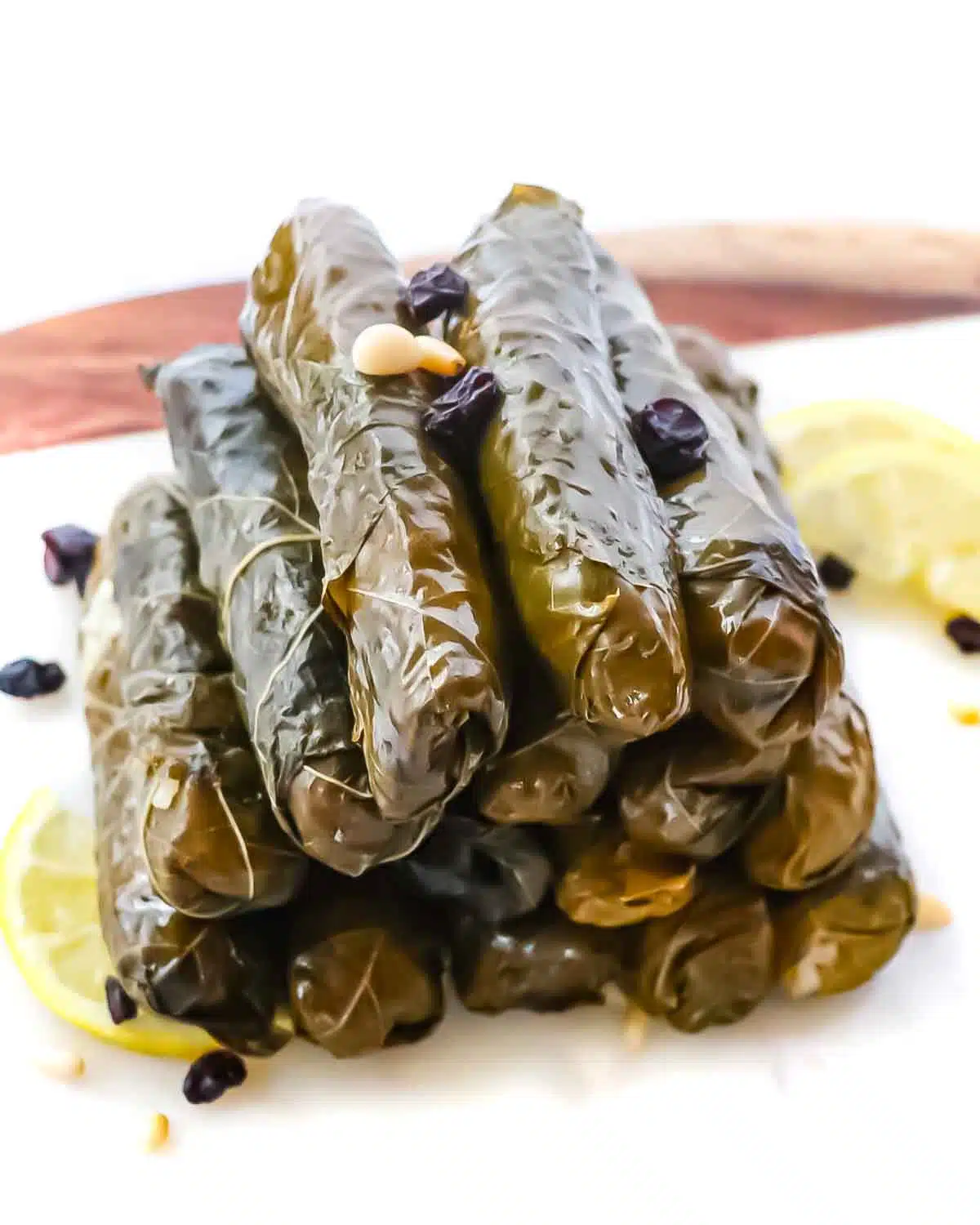 Stuffed Turkish grape leaves stacked on a platter.