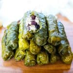 Pyramad of Turkish grape leaves with the top grape leaf showing the stuffing.
