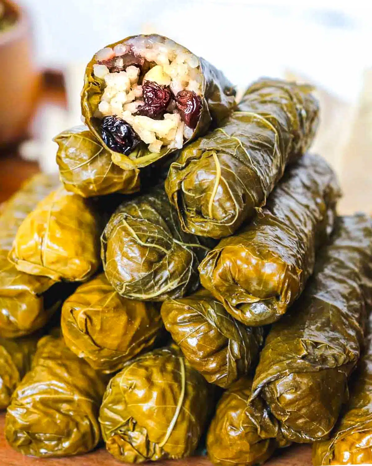 Grape leaves stacked into a pyramid with the top one showing the inside.