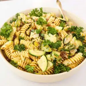 Creamy tahini pasta garnished with parsley.