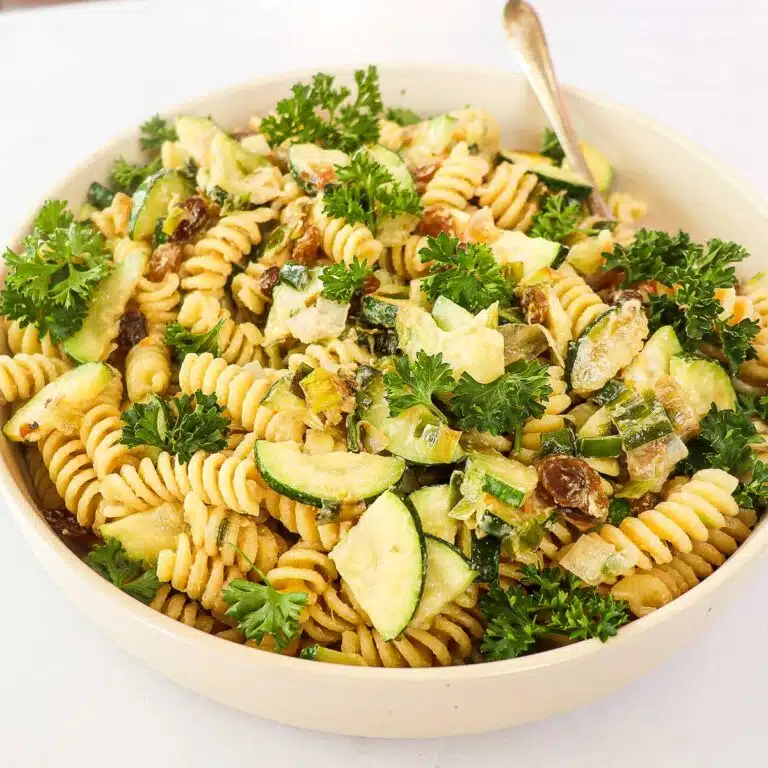 Creamy tahini pasta garnished with parsley.