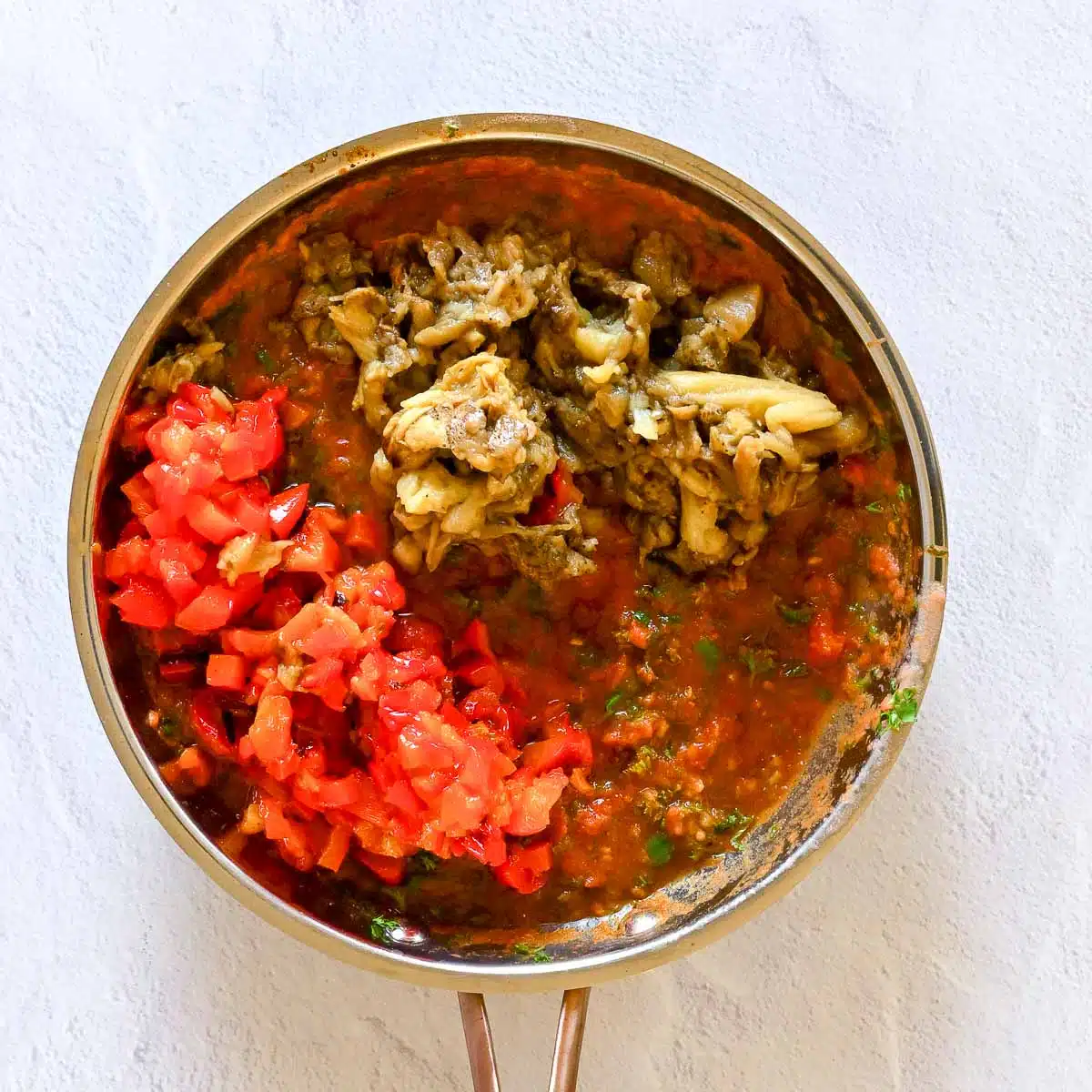 Roasted eggplant and red bell peppers rough chopped and added to the skillet. 