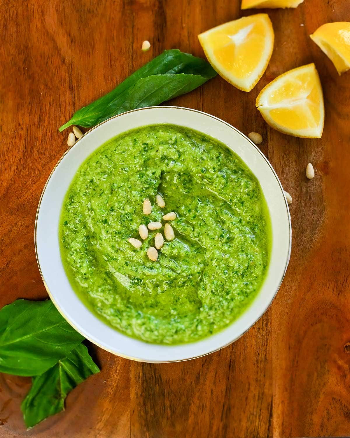 Lemon pesto in a small bowl with pine nuts on top.