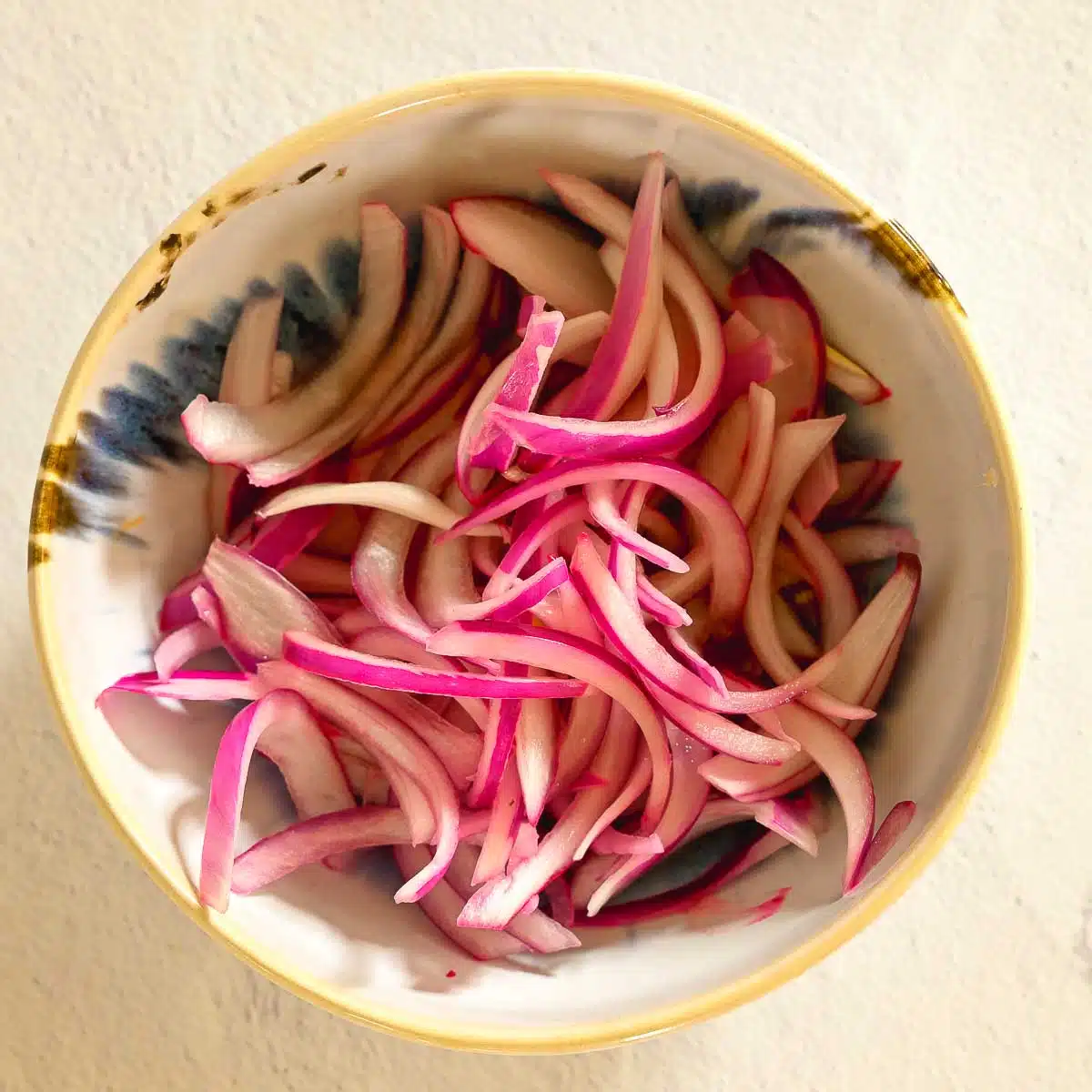 Red onions cut into slivers and marinating in lemon juice.