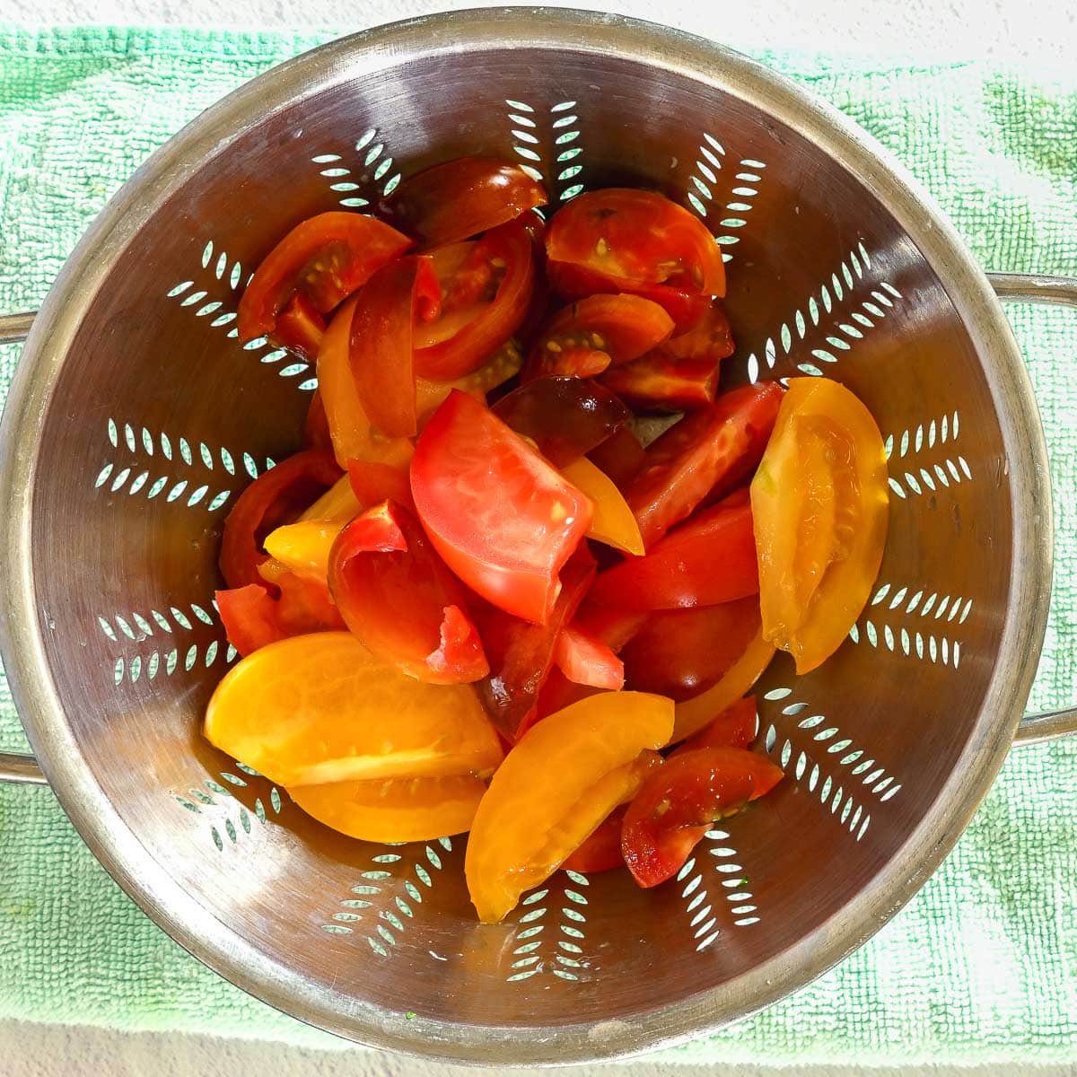 Sliced tomatoes drying in a colander.