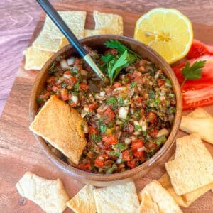 Turkish ezme in a bowl with pita chips near it.