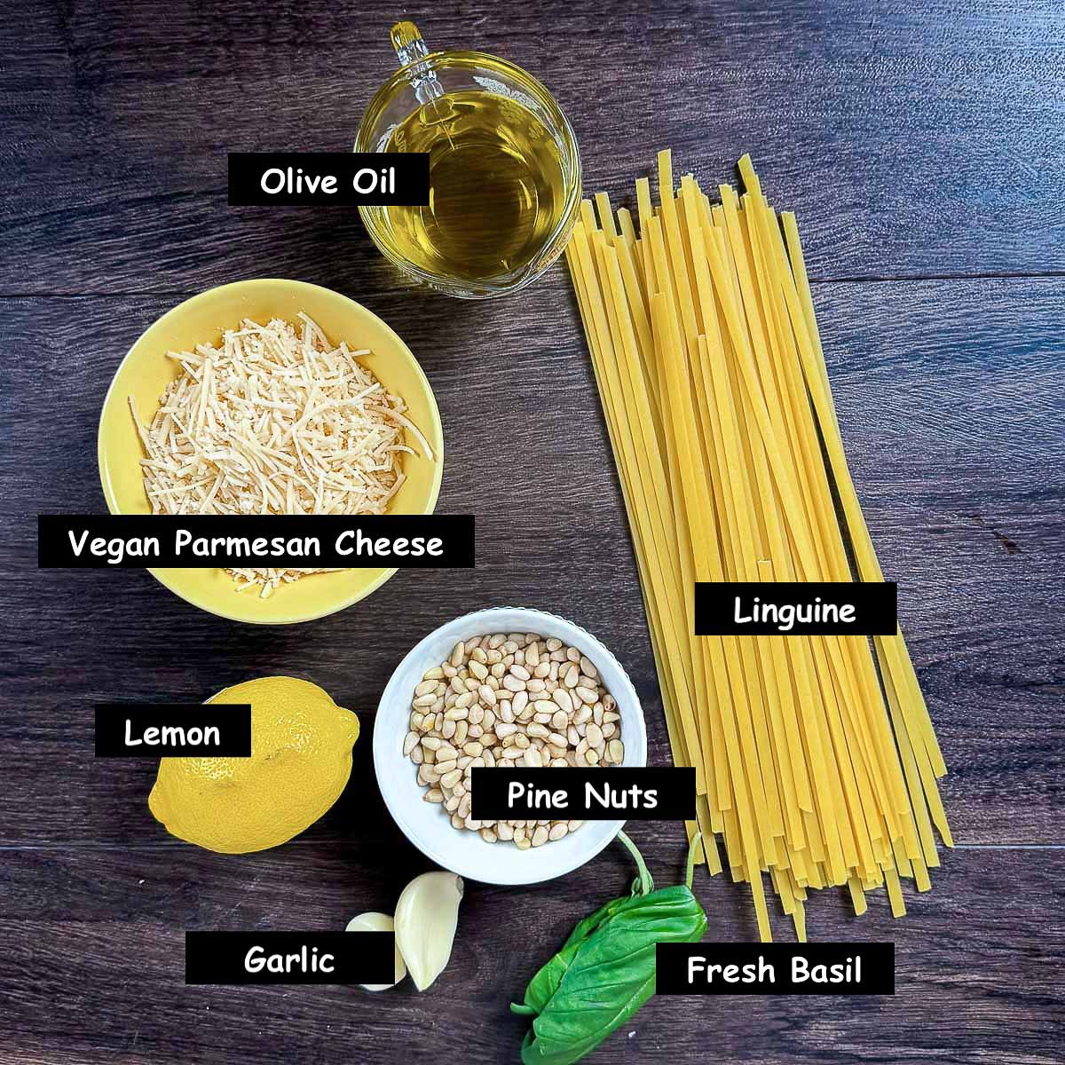 Pesto al pasta ingredients: linguine, basil, pine nuts, garlic, lemon, vegan parmesan cheese and olive oil.