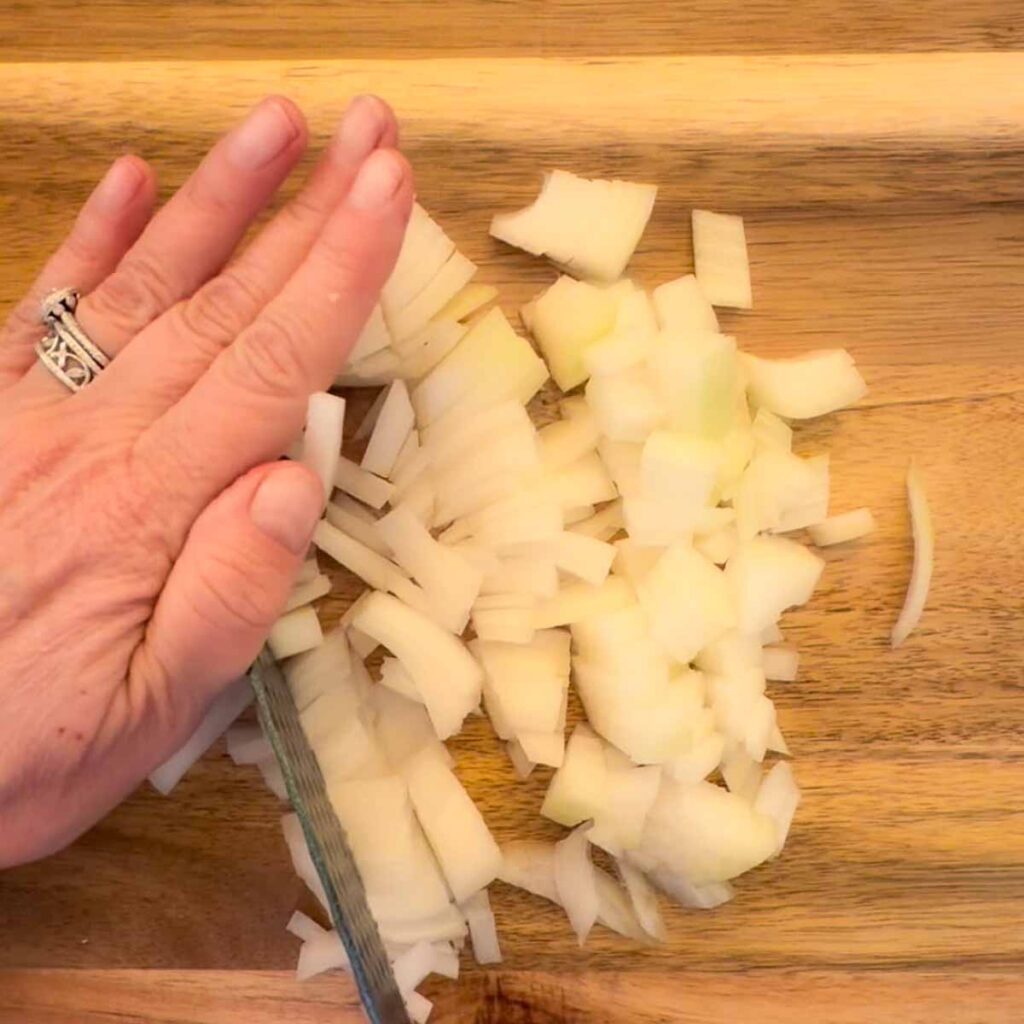 A hand dicing onions.