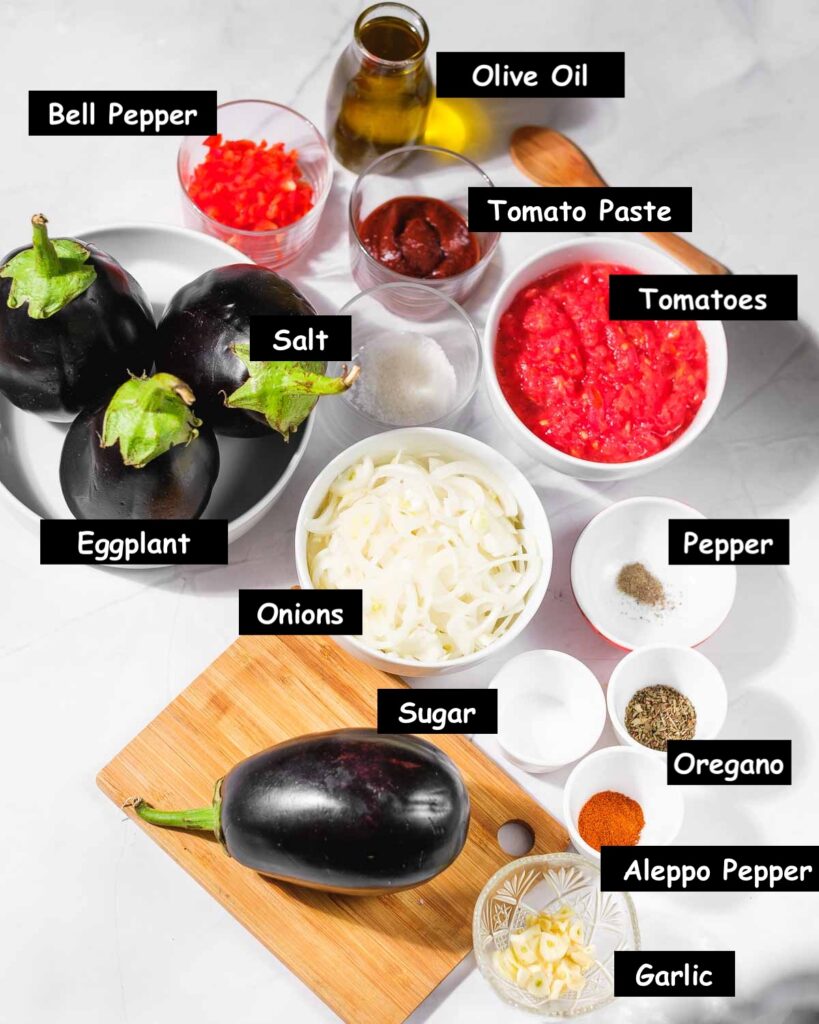 Imam Bayildi (Turkish Stuffed Eggplant) ingredients: Eggplant, onions, tomatoes, tomato paste, olive oil, bell peppers, garlic, and spices.