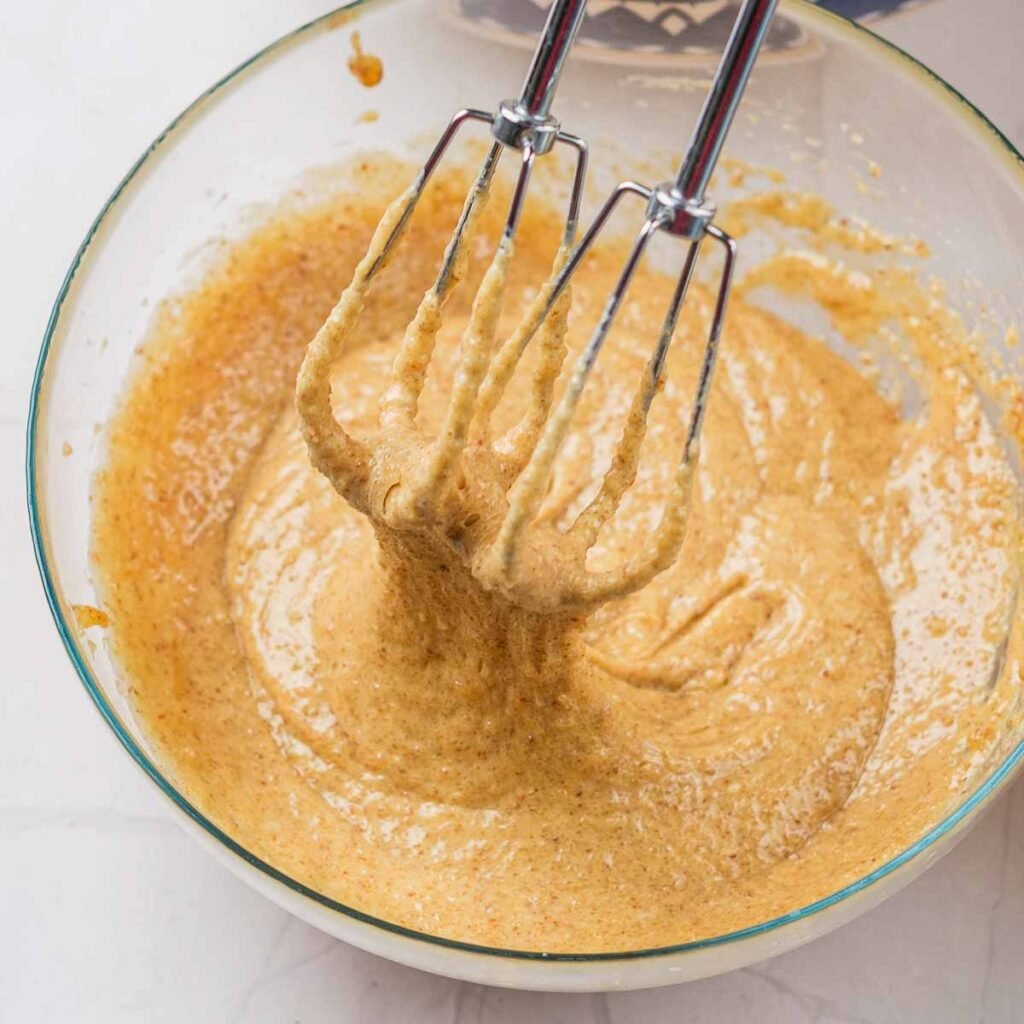 Wet ingredients are fully blended together with a mixer, and the wet ingredients are on the beaters.